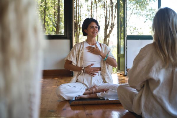 Meditation und Atemübungen bzw. Atemtechniken in einem Raum mit einer Yoga-Lehrerin Meditation und Atemübungen bzw. Atemtechniken in einem Raum mit einer Yoga-Lehrerin